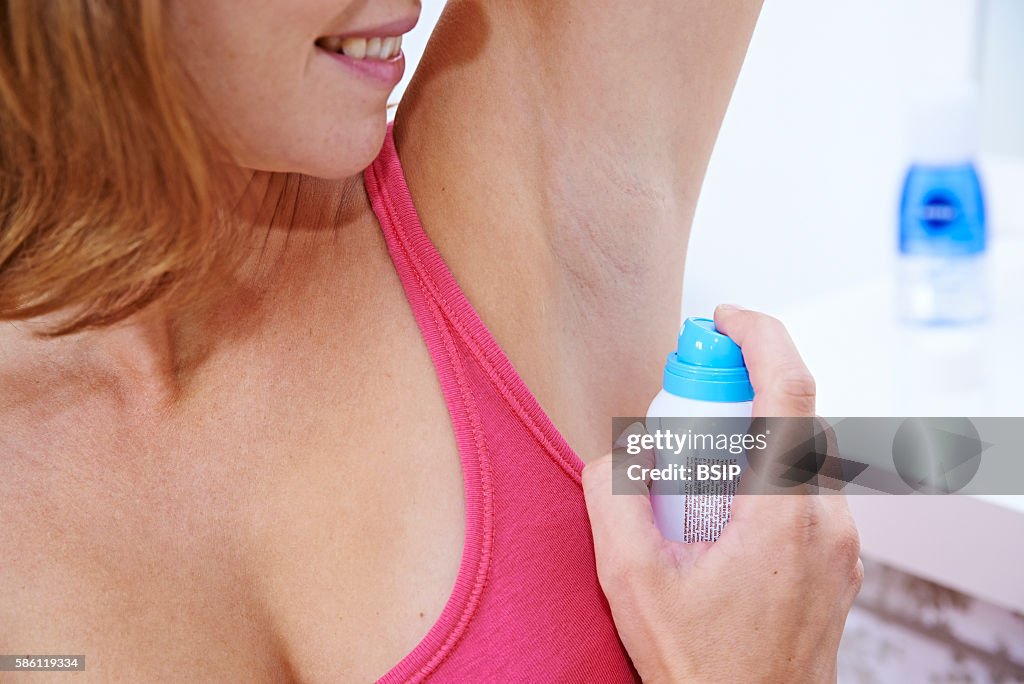 Woman applying spray deodorant