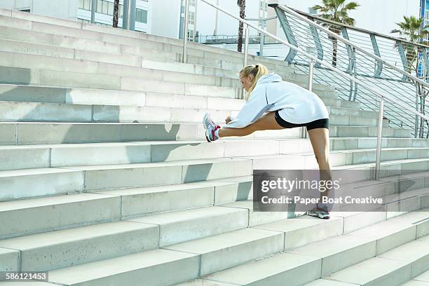 woman stretching her hamstrings by the stairs - hamstring stock pictures, royalty-free photos & images