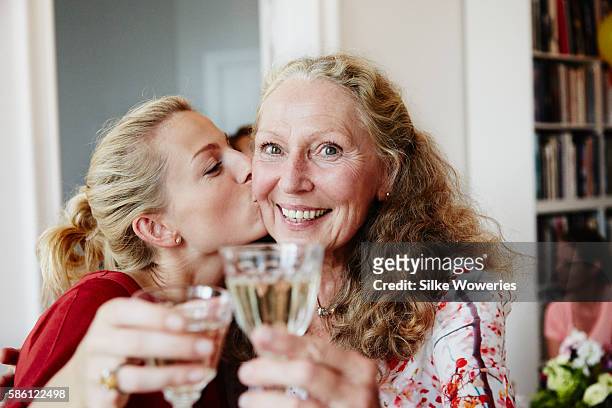 happy friends raise a glas of sparkling wine at a party - party inside stockfoto's en -beelden