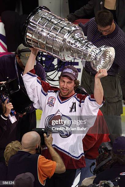 Peter Forsberg of the Colorado Avalanche raises the Stanley Cup in Denver, Coloardo after losing his spleen earlier, during the Western Conference...