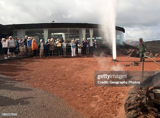 Tourists watch steam rise from geyser spout, Parque Nacional de Timanfaya, national park, Lanzarote, Canary Islands, Spain.