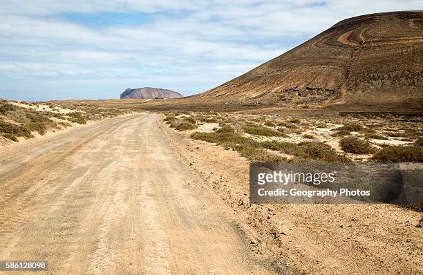 Unmade road passing Agujas Grandes volcano, La Isla Graciosa, Lanzarote, Canary Islands, Spain.