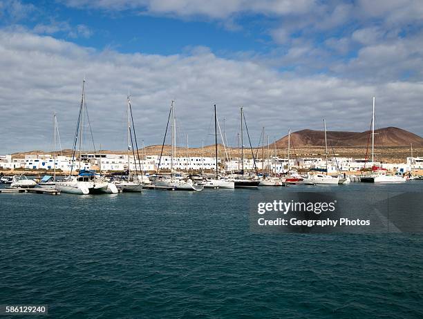 Yachts at moorings Caleta de Sebo harbor and village, La Isla Graciosa, Lanzarote, Canary Islands, Spain.