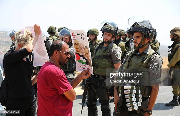 Israeli Security forces block the road as Palestinians and a group of foreign activists carry posters of Bilal Kayed who stage hunger strike and...