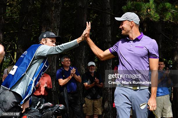Maximilian Kieffer of Germany gets a high five from his caddy after chipping in on hole 18 after winning his match on day two of the Aberdeen Asset...