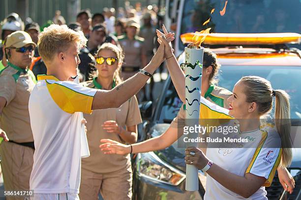 Coca-Cola Olympic Torch Bearer Cody Simpson shares a #ThatsGold moment with his little sister Alli as he hands the Olympic Flame over to her prior to...