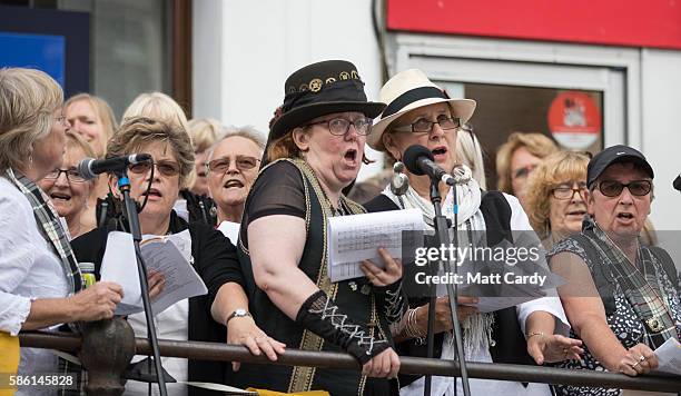 Choir sings as people wait for the giant 12-metre tall Man Engine to be unveiled to the public in Penzance on August 5, 2016 in Cornwall, England....