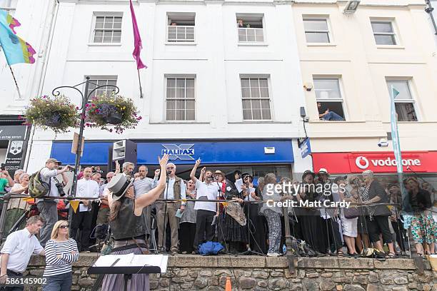 Choir sings as people wait for the giant 12-metre tall Man Engine to be unveiled to the public in Penzance on August 5, 2016 in Cornwall, England....