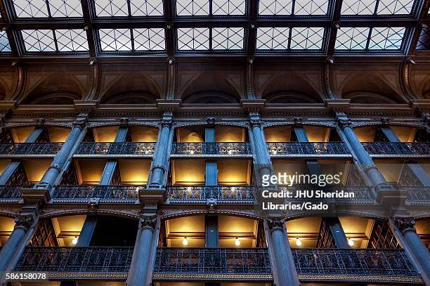 Low-angle shot of the levels of the George Peabody Library, a research library for Johns Hopkins University, with cast iron railings and exposed...