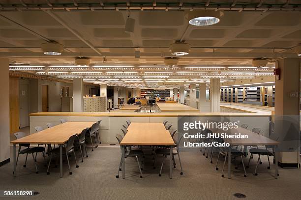 Study space, complete with tables and chairs on wheels, with stacks and filing cabinets visible in the background, on A-Level of the Milton S....