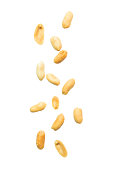 Peeled and salted peanut falling on white background