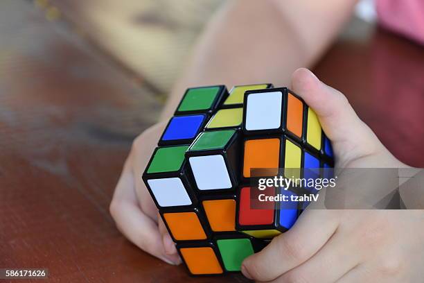 hands playing a cube game - rubik's cube stockfoto's en -beelden