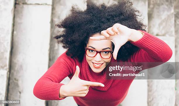 smiling young woman making frame with fingers on stairs - red eyeglasses stock pictures, royalty-free photos & images