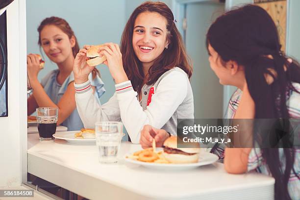 school meals - girl eating burger stock pictures, royalty-free photos & images
