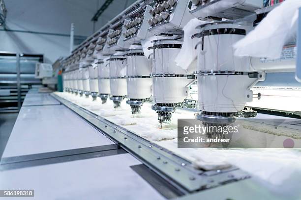 close up on the embroidery machine at a clothing factory - needlecraft product stock pictures, royalty-free photos & images