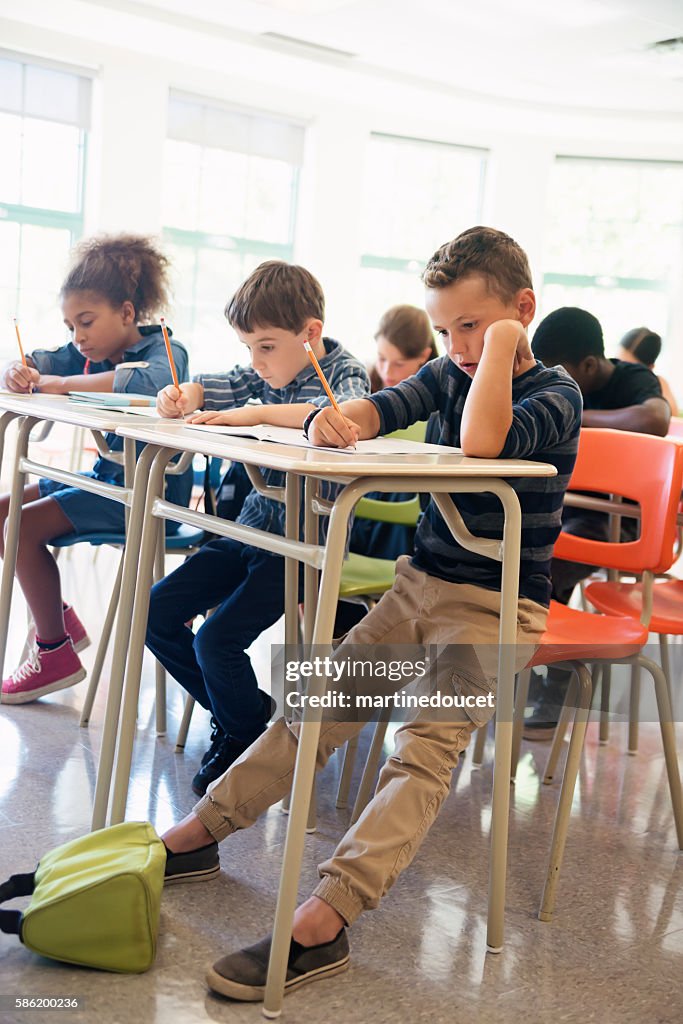 Elementary students taking a test in classroom.