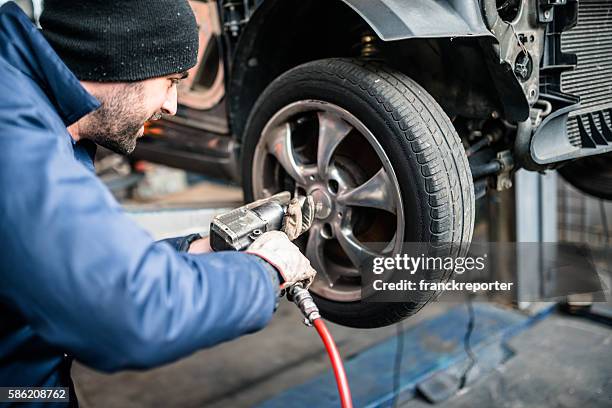 tire repairer changing the car tire - auto repair shop stockfoto's en -beelden