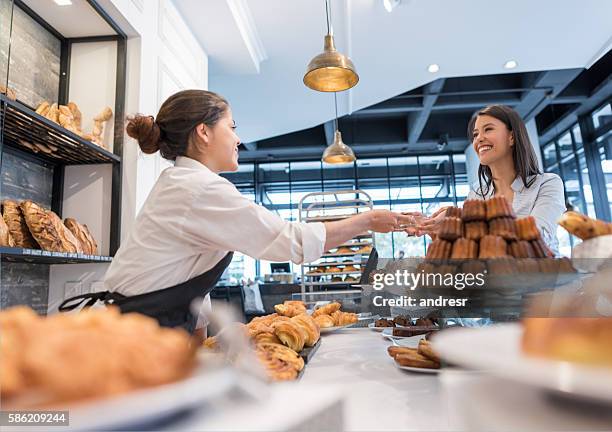 mujer feliz comprando pasteles en una panadería - america patisserie fotografías e imágenes de stock