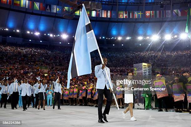 Nijel Amos of Botswana carries the flag during the Opening Ceremony of the Rio 2016 Olympic Games at Maracana Stadium on August 5, 2016 in Rio de...