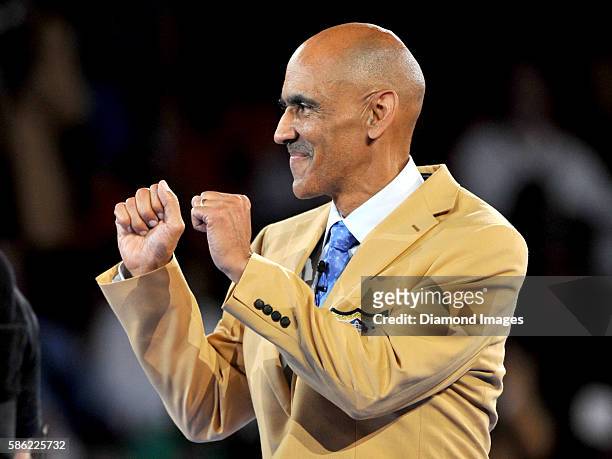 Hall of Fame enshrinee, coach Tony Dungy gestures toward the crowd after receiving his gold jacket during the Pro Football Hall of Fame Gold Jacket...