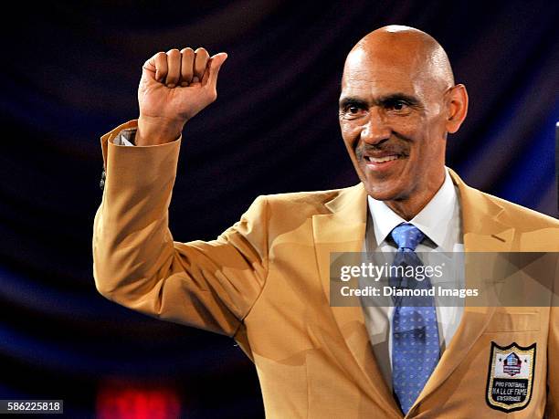 Hall of Fame enshrinee, coach Tony Dungy pumps his fist to the crowd after receiving his gold jacket during the Pro Football Hall of Fame Gold Jacket...