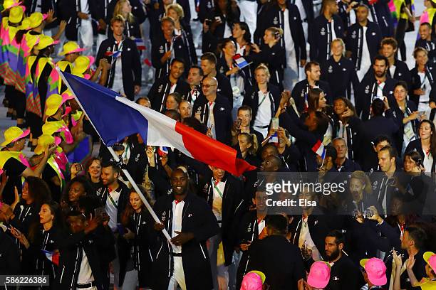 Flag bearer Teddy Riner of France leads his team during the Opening Ceremony of the Rio 2016 Olympic Games at Maracana Stadium on August 5, 2016 in...