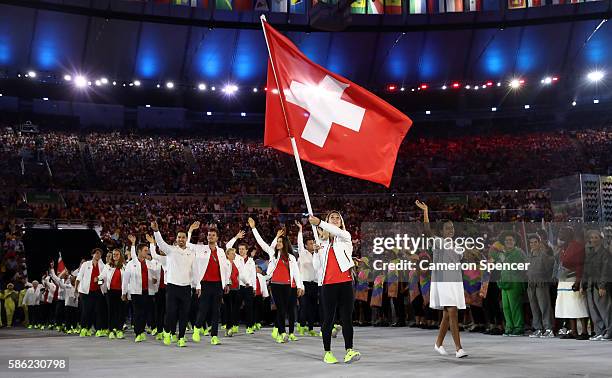 Giulia Steingruber of Switzerland carries the flag during the Opening Ceremony of the Rio 2016 Olympic Games at Maracana Stadium on August 5, 2016 in...