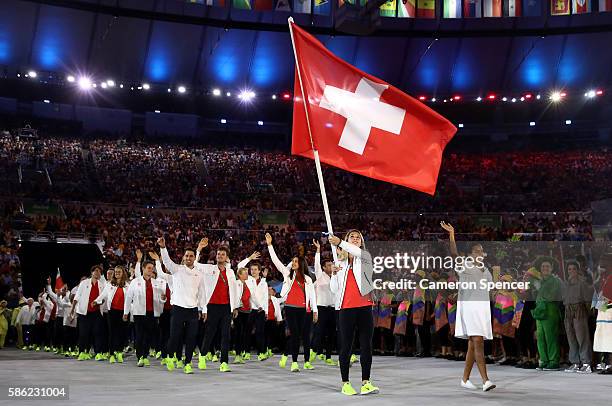 Giulia Steingruber of Switzerland carries the flag during the Opening Ceremony of the Rio 2016 Olympic Games at Maracana Stadium on August 5, 2016 in...