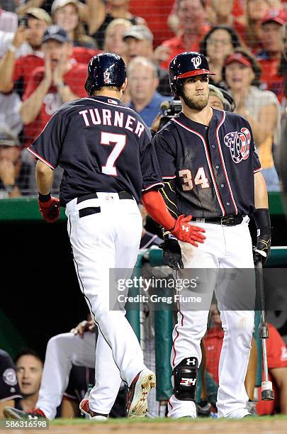 Trea Turner of the Washington Nationals celebrates with Bryce Harper after hitting a home run in the fifth inning against the San Francisco Giants at...