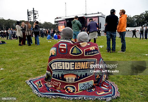 Festival goers cover up under a blanket during the 2016 Outside Lands Music And Arts Festival at Golden Gate Park on August 5, 2016 in San Francisco,...