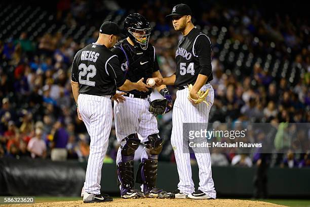 Colorado Rockies manager Walt Weiss takes the ball from pitcher Carlos Estevez after he gave up three runs in the ninth inning during the game...