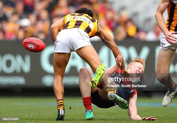 Cyril Rioli of the Hawks tackles Clayton Oliver of the Demons in a big, high tackle during the round 20 AFL match between the Melbourne Demons and...