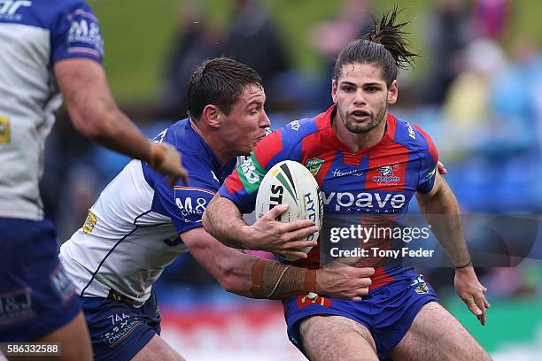 Jake Mamo of the Knights is tackled during the round 22 NRL match between the Newcastle Knights and the Canterbury Bulldogs at Hunter Stadium on...