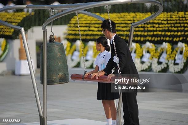 Japanese children rings a gong as they participate the ceremony at the Peace Center Memory in Hiroshima for the commemoration of the 71th anniversary...