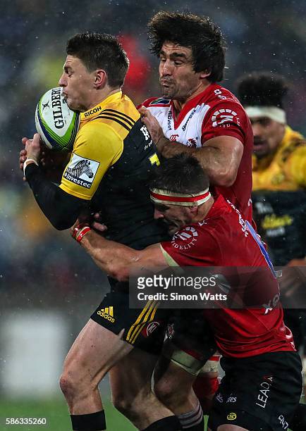 Beauden Barrett of the Hurricanes is tackled by Warwick Whiteley and Jaco Kriel of the Lions during the 2016 Super Rugby Final match between the...