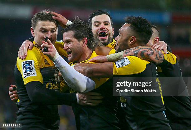 Cory Jane of the Hurricanes celebrates a try with teammates Beauden Barrett and James Marshall during the 2016 Super Rugby Final match between the...