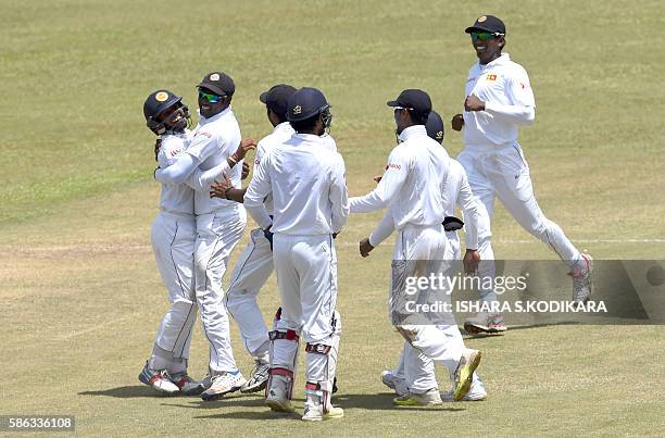 Sri Lanka's captain Angelo Mathews and cricketer Kusal Mendis celebrate with teammates the wicket of Australian cricketer Peter Nevill during the...