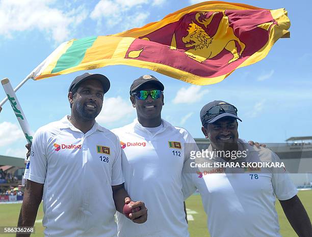 Sri Lanka's captain Angelo Mathews, and teammates Rangana Herath and Dilruwan Perera leave the grounds with the stumps after victory in the second...