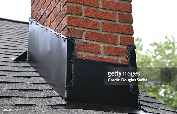 close-up of brick chimney on house roof with medal flashing - modern garden shed stockfoto's en -beelden