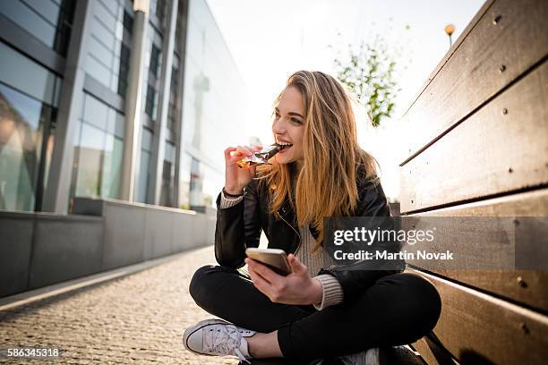 sweet mobile life - in street - essen mund benutzen stock-fotos und bilder