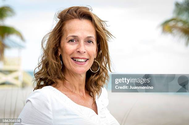 ungefähr fünfzig frau  - hispanic man on beach stock-fotos und bilder