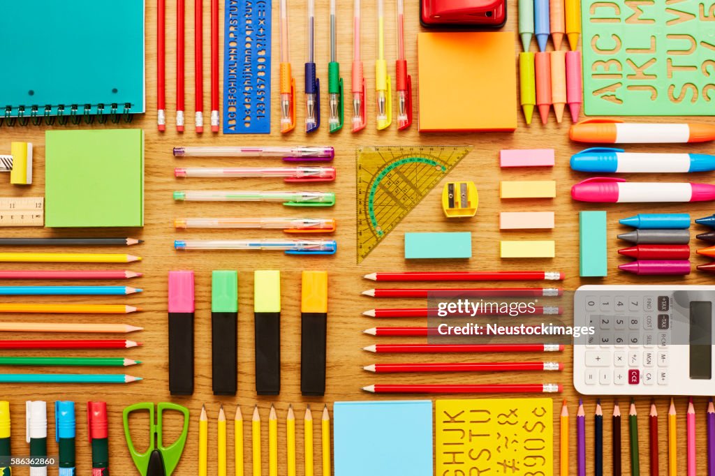 Office and school supplies arranged on wooden table - Knolling