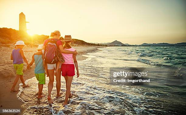 familia caminando en la playa al atardecer - islas baleares fotografías e imágenes de stock