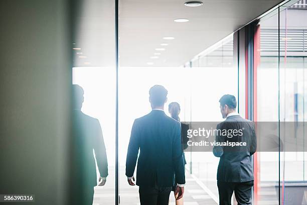 tre collegues si incontrano in ufficio - man suit using phone tablet foto e immagini stock