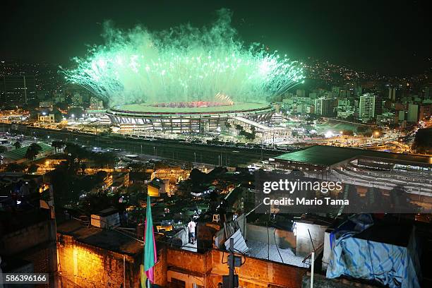 Fireworks explode over Maracana stadium with the Mangueira 'favela' community in the foreground during opening ceremonies for the Rio 2016 Olympic...