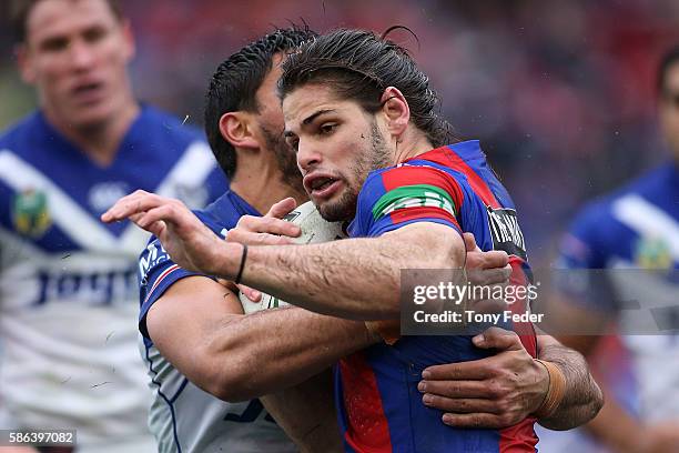 Jake Mamo of the Knights is tackled by the Bulldogs defence during the round 22 NRL match between the Newcastle Knights and the Canterbury Bulldogs...