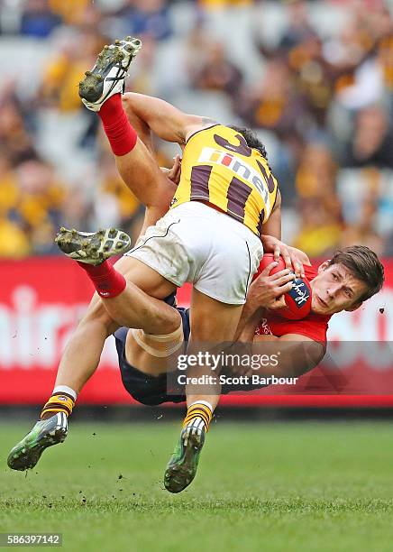 Sam Weideman of the Demons is hit in a big tackle by Cyril Rioli of the Hawks during the round 20 AFL match between the Melbourne Demons and the...