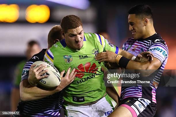 Brenko Lee of the Raiders is tackled by the Sharks defence during the round 22 NRL match between the Cronulla Sharks and the Canberra Raiders at...