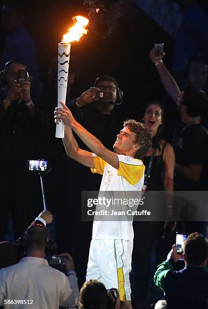 Gustavo Kuerten aka Guga carries the Olympic torch during the opening ceremony of the 2016 Summer Olympics at Maracana Stadium on August 5, 2016 in...