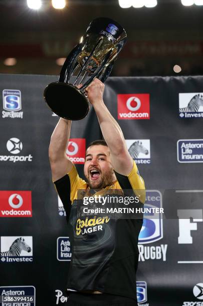 Dane Coles of the Hurricanes holds up the trophy to celebrate the team's victory after the Super Rugby final match between the Wellington Hurricanes...